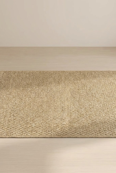 Beige woven mat on a wooden floor with a neutral background