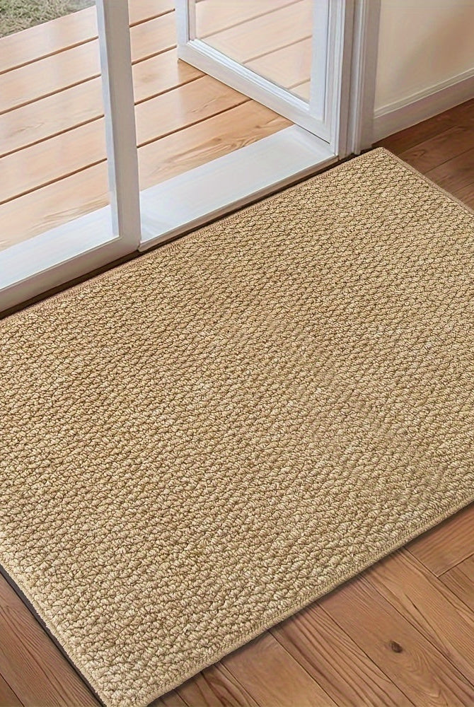 Beige doormat on a wooden floor in front of a glass door.