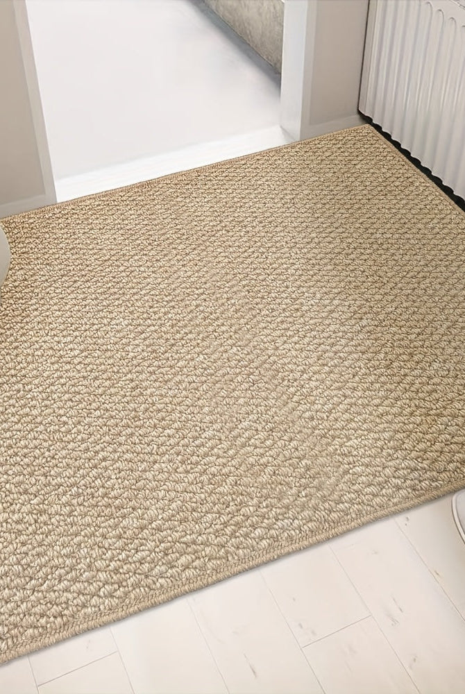 Beige rug on a light wooden floor with a chair and white shoes in the foreground.
