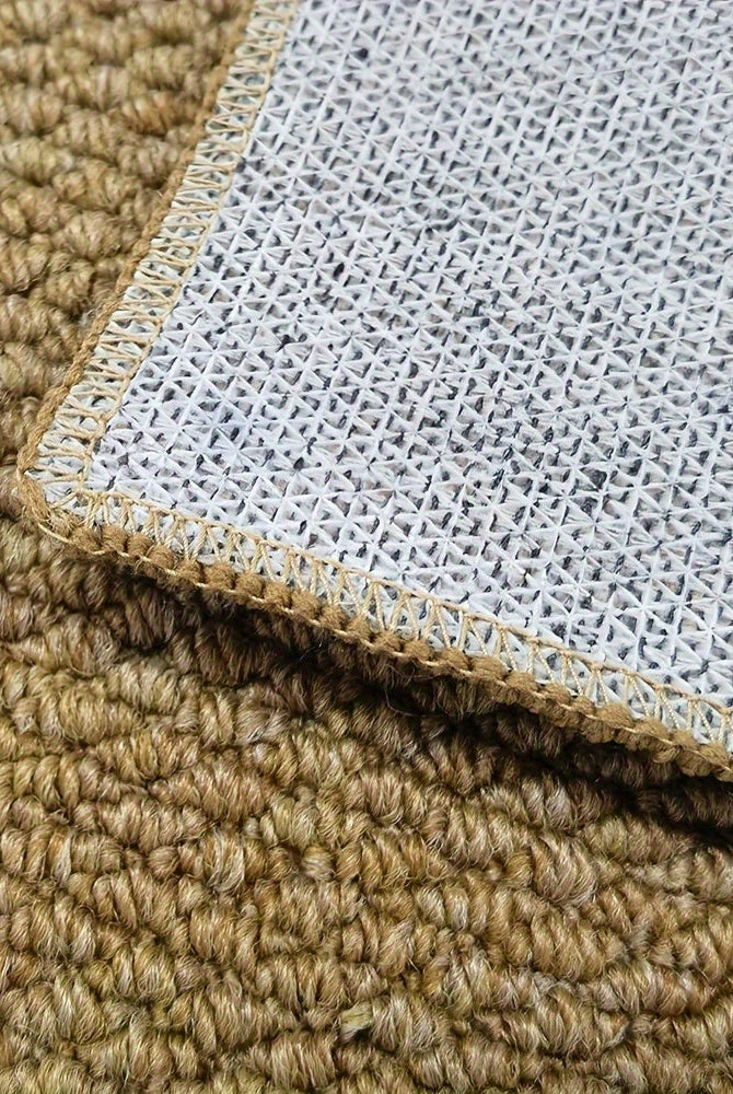 Close-up of a textured beige carpet corner with a white underlay.