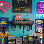 A retro-themed room scene featuring a black wall-mounted shelf with a dripping design, holding a pixelated orange-red character toy and a vintage arcade joystick. The wall is decorated with neon-style signs, framed retro posters, pixel art, and several arcade game cabinets and cartridges at the bottom.
