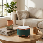 A humidifier on a wooden coffee table in a living room with a couch and plant in the background.