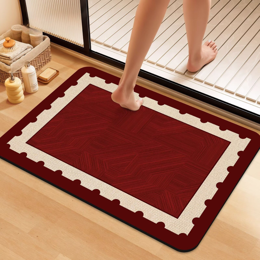 Red doormat with white border on a wooden floor, person stepping onto it.