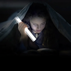 Person lying down in a dark setting, holding a light source.