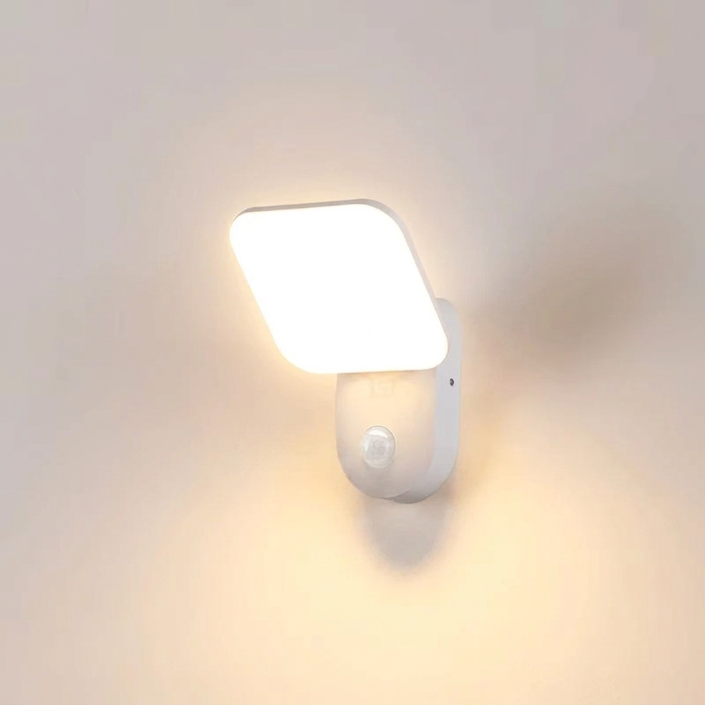 White wall-mounted light fixture with a sensor on a plain background