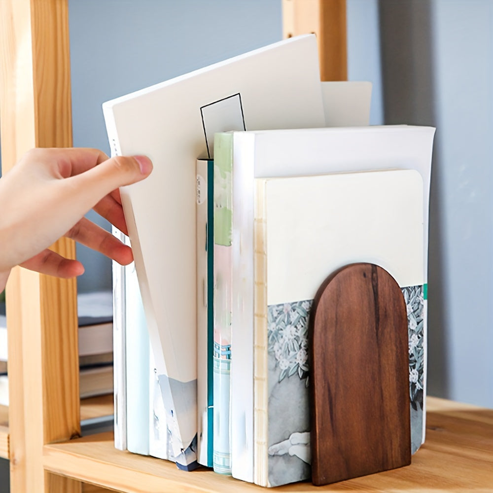 Hand opening a book with a wooden cover on a shelf.