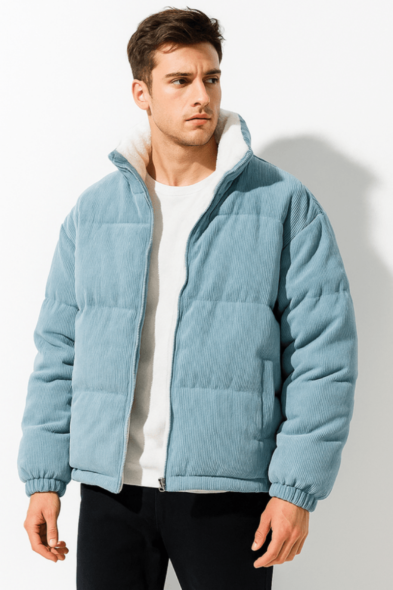 Man wearing a light blue puffer jacket against a white background
