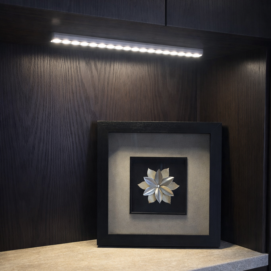 Decorative wall art piece on a shelf with dark wood cabinets and lighting.