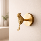 Decorative brass bird wall hook on a beige wall