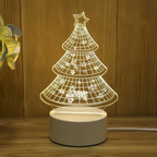 3D Christmas tree lamp on a wooden surface with a plant in the corner