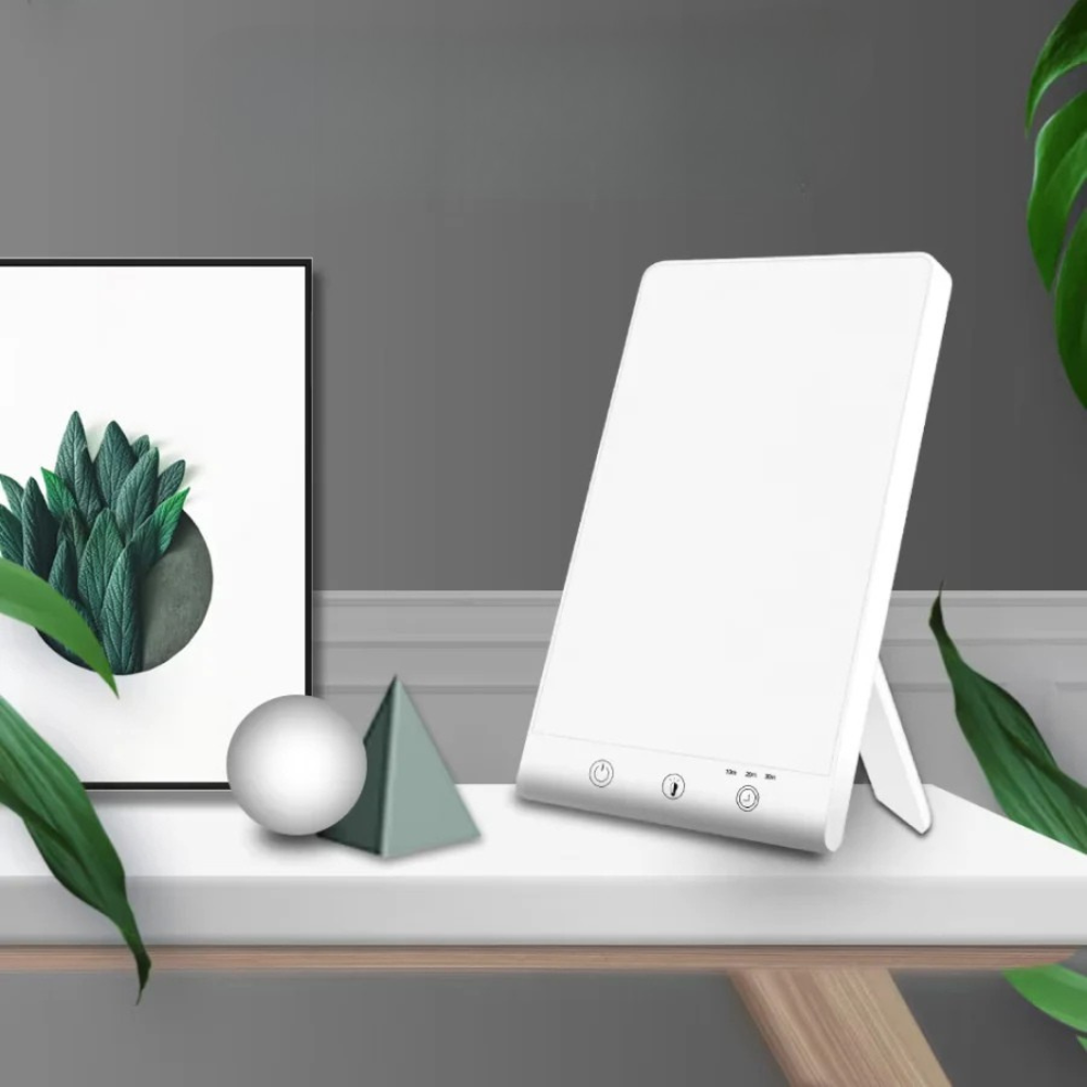 White electronic device on a shelf with decorative items and plants