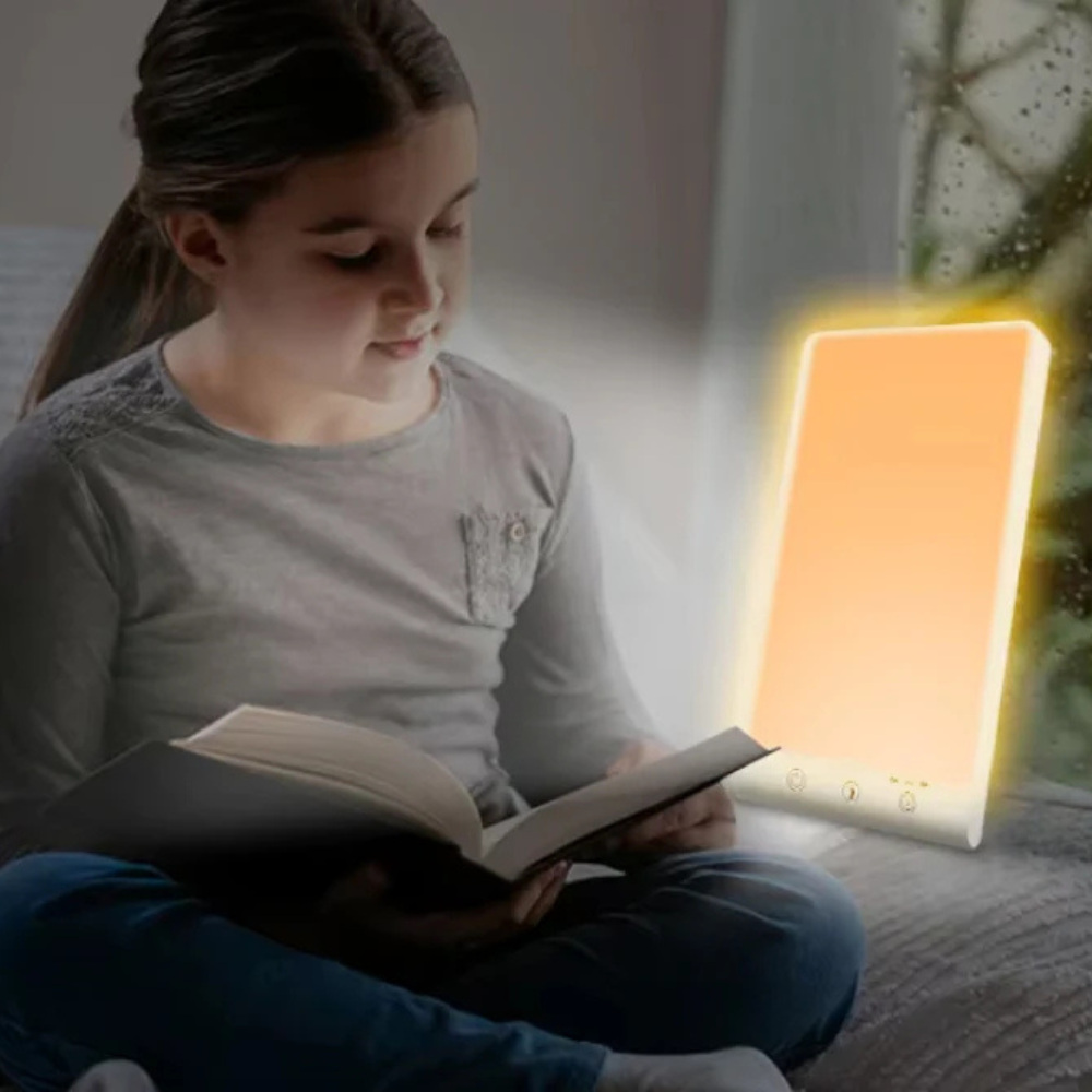 Child reading a book with a soft light lamp next to them