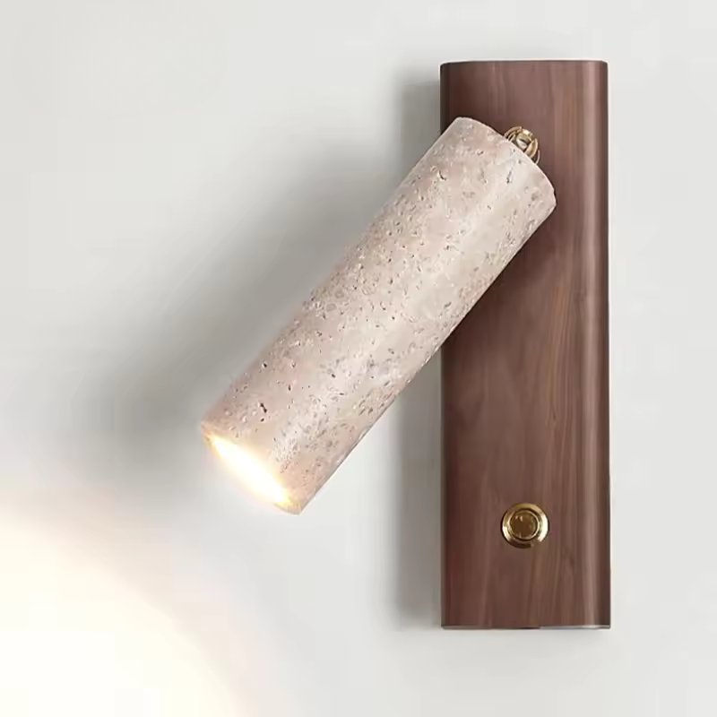 A modern wall-mounted light fixture with a cylindrical beige stone shade and a dark brown rectangular wood backplate, shown lit against a plain light background.
