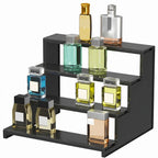 Black multi-tiered display shelf with various small bottles on a white background