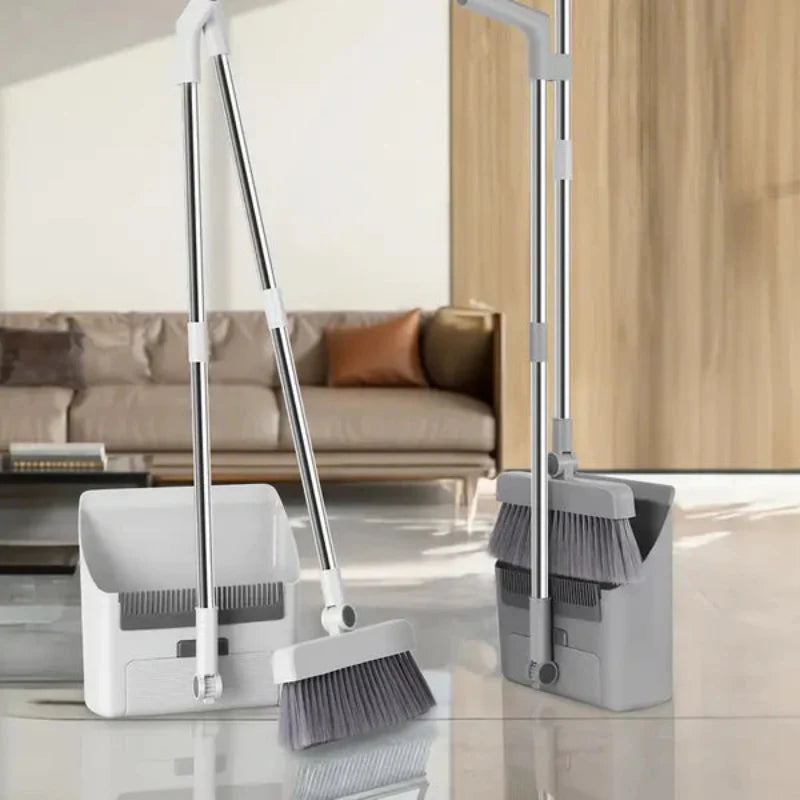 Set of cleaning tools including brooms and dustpans on a reflective surface with a modern interior background.