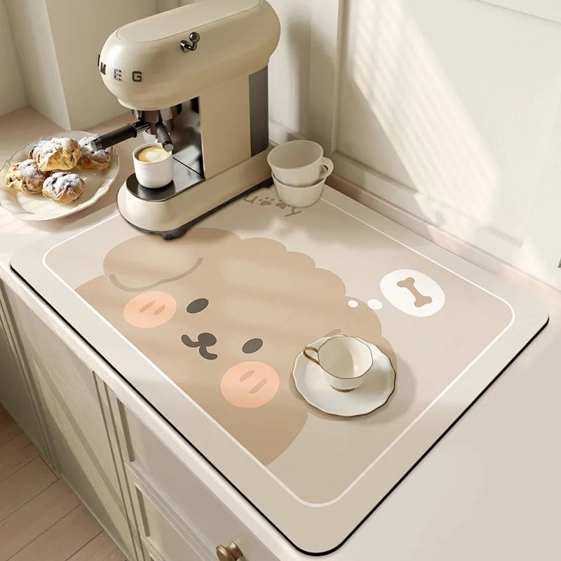 Kitchen counter with a cartoon cat design mat, coffee machine, and pastries.