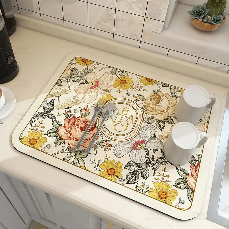 Floral design placemat on a kitchen counter with cups and cutlery.