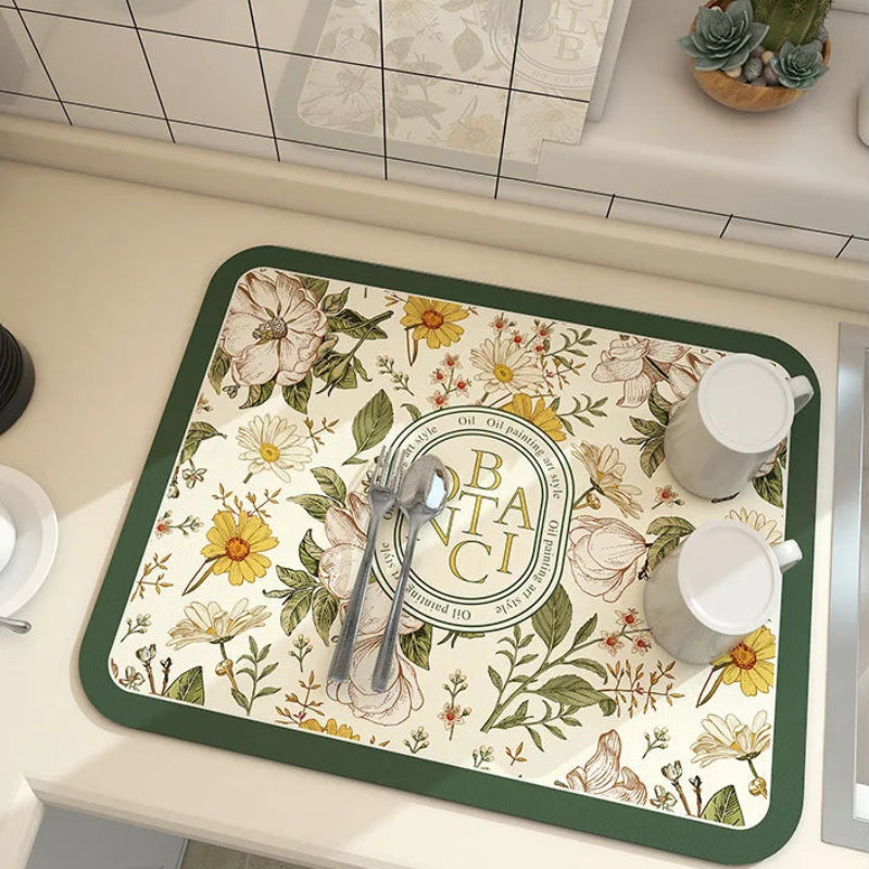 Floral patterned placemat with cutlery and cups on a kitchen counter.
