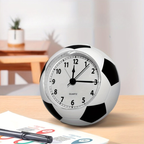 Soccer ball-shaped clock on a desk with a pen and paper