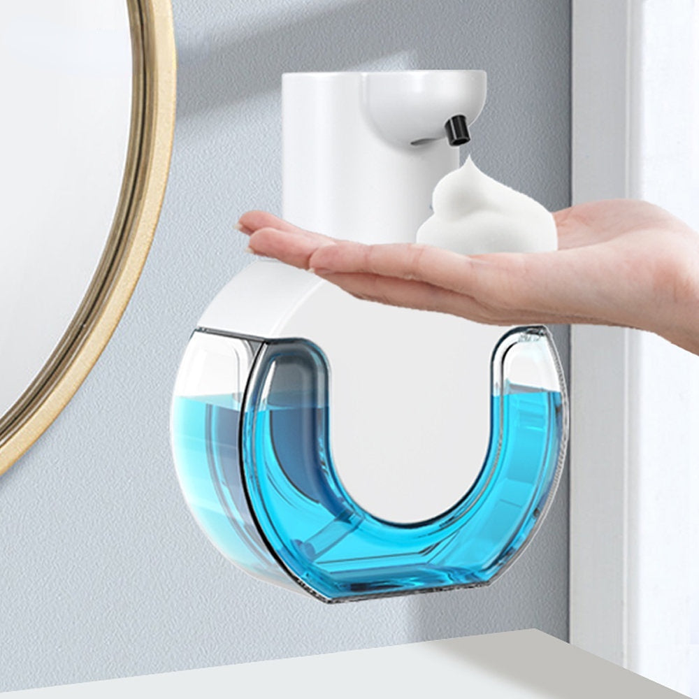 Hand soap dispenser with blue liquid on a light gray wall.