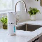 White water filter on a kitchen counter with a sink and plants in the background