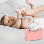 Baby lying on a bed with a pink tissue box and wipes