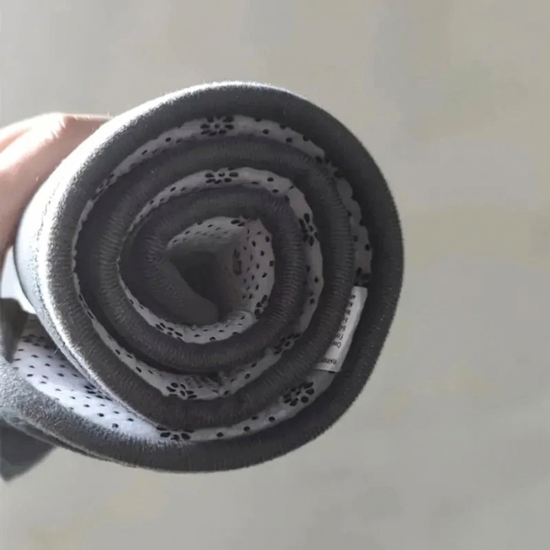 Coiled black flexible hose with measurement label on a light background