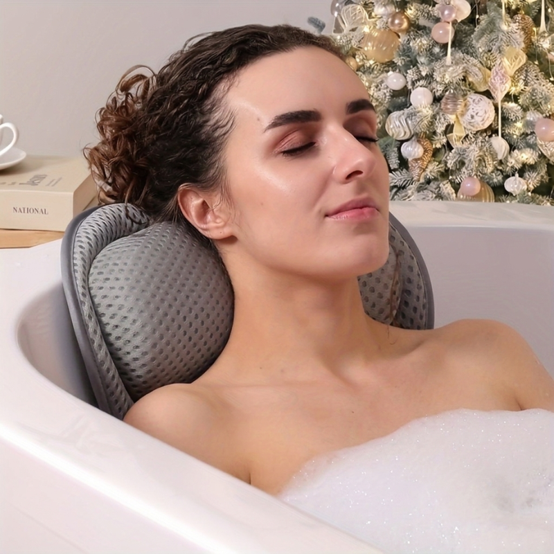 Woman relaxing in a bathtub with a neck pillow, Christmas tree in the background