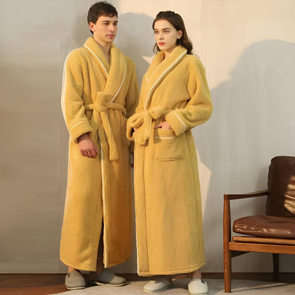 Two people wearing yellow robes standing in a room with a chair.