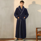 Man wearing a navy blue robe with white trim in a room.