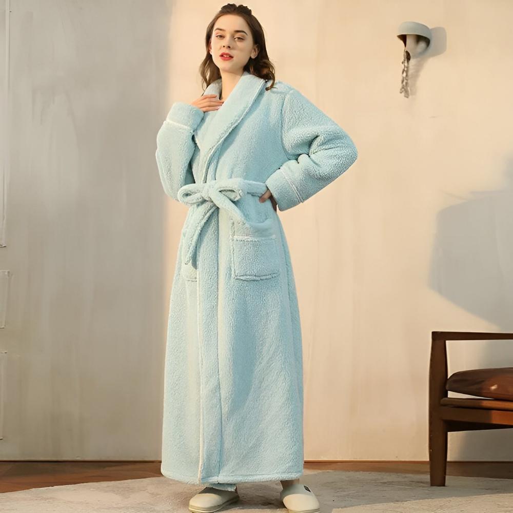 Woman wearing a light blue robe indoors.