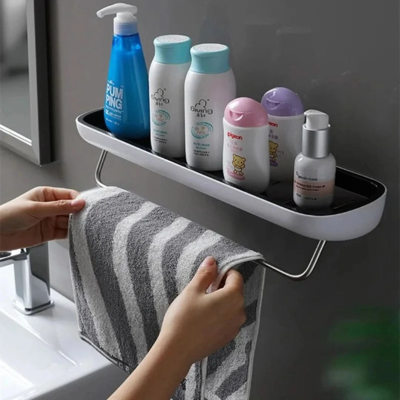 Bathroom shelf with toiletries and a towel, with a hand reaching for the towel.