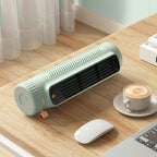 Small green space heater on a desk with a cup of coffee and computer mouse.