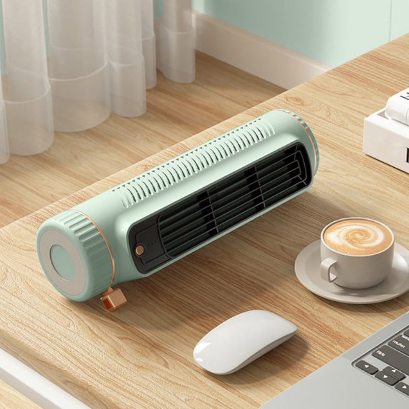 Small green space heater on a desk with a cup of coffee and computer mouse.