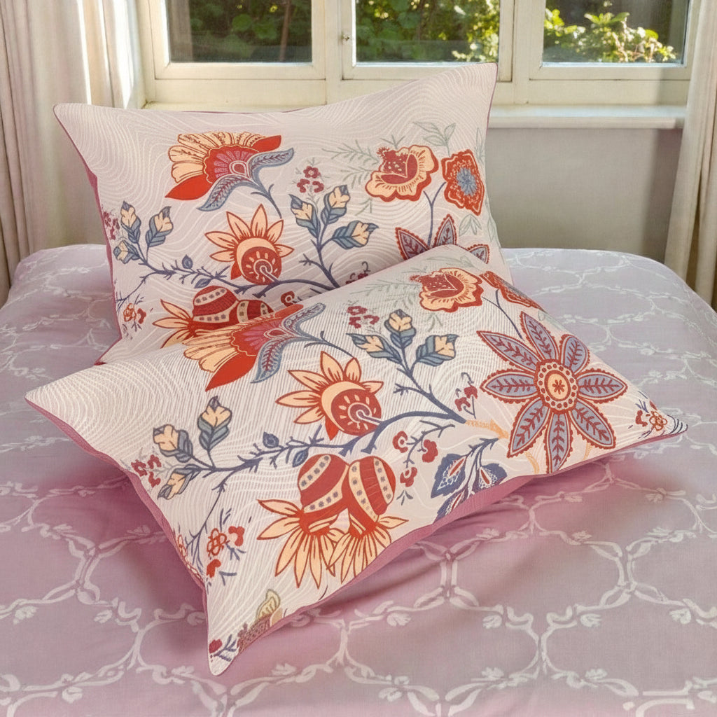 Floral patterned pillows on a bed with a window in the background
