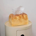 Tissue box designed like a loaf of bread on a white surface with a light gray background