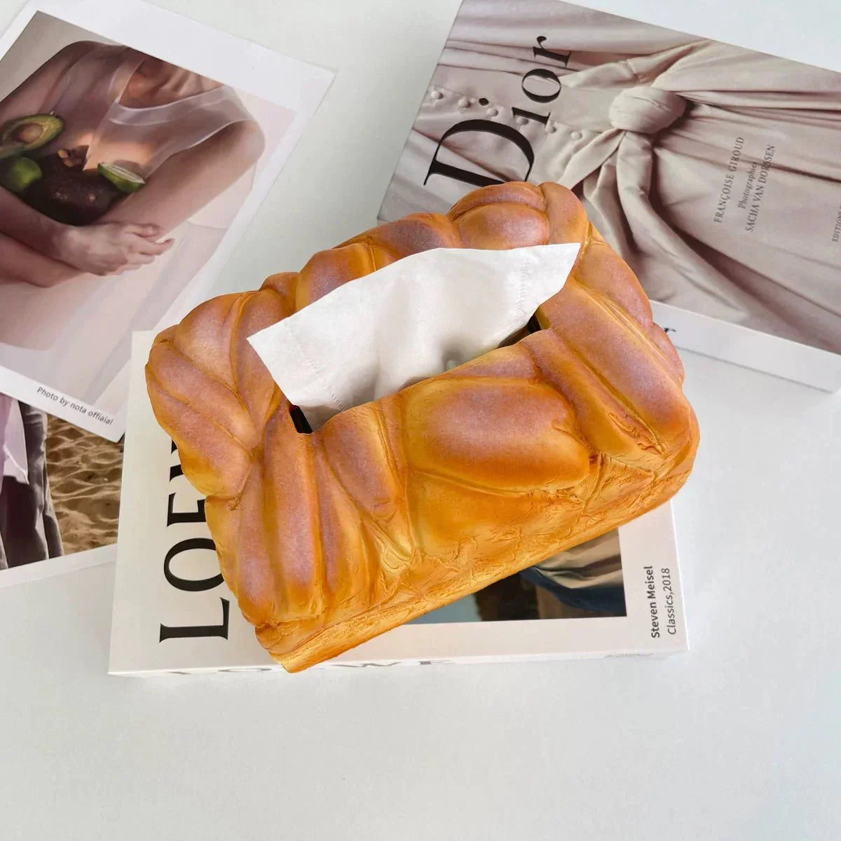 Bread-shaped tissue box on a magazine with visible brand names