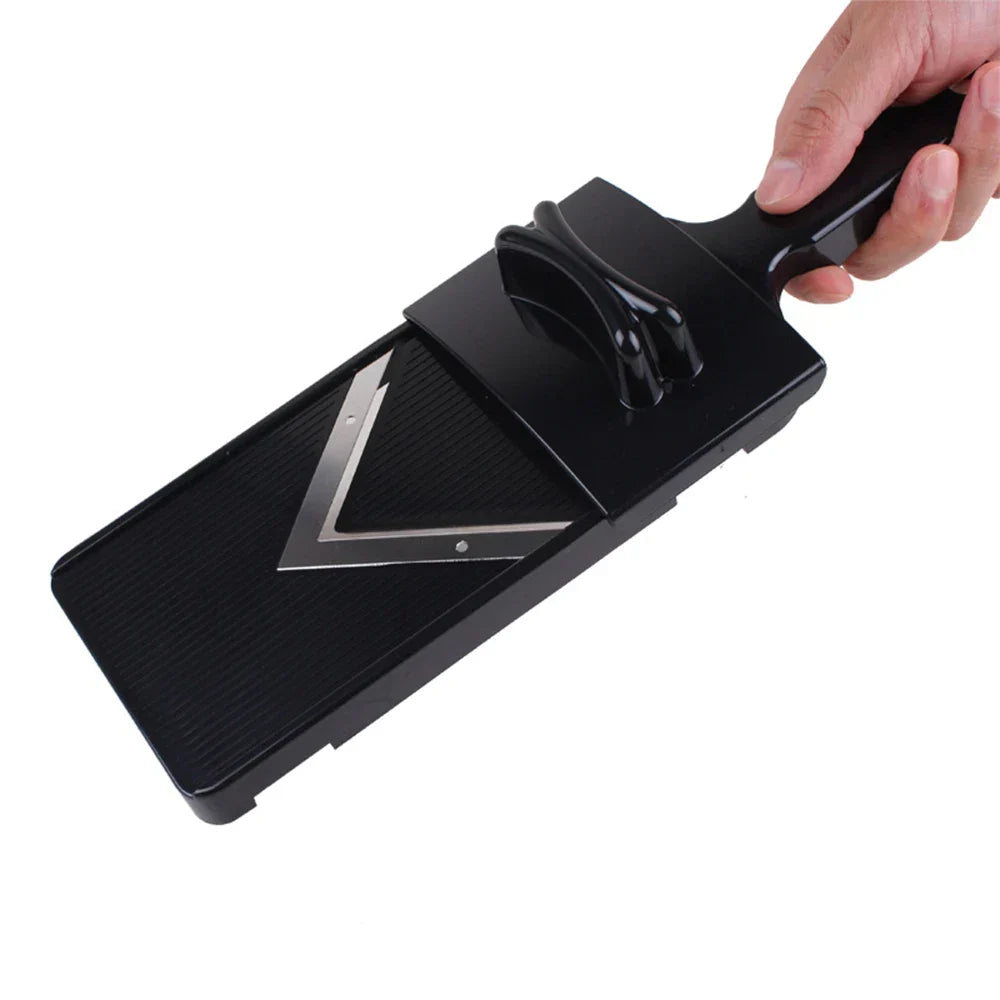 Black vegetable slicer with a hand holding it on a white background