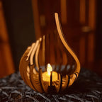 Wooden lantern with a lit candle inside on a textured surface.