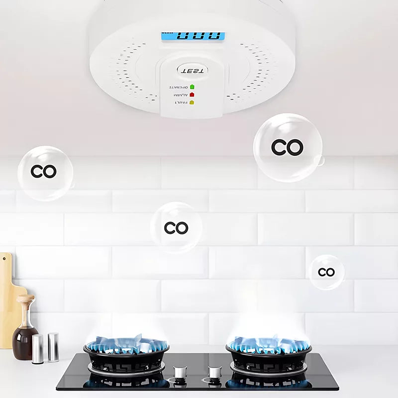 CO detector above a gas stove with blue flames on a white tiled wall.