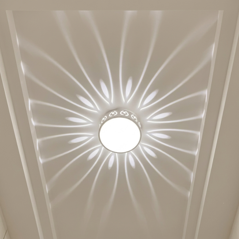 Ceiling light fixture with decorative pattern on a white ceiling