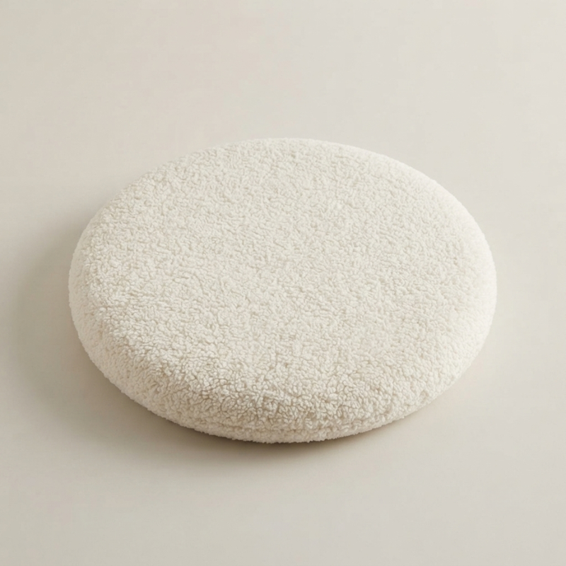 Round, textured white stone on a light beige background