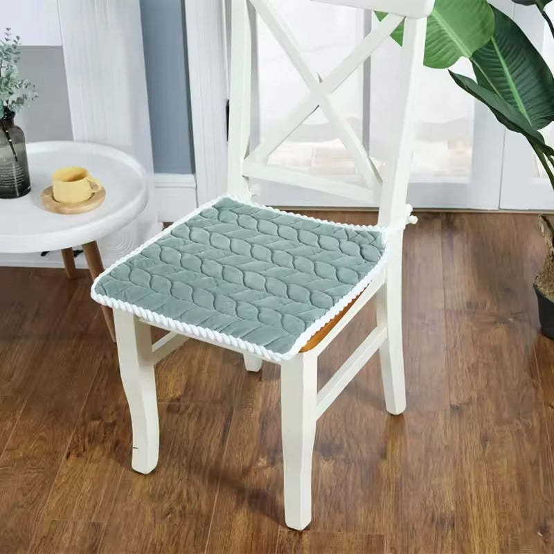 Chair with a green cushion on a wooden floor in a room setting.