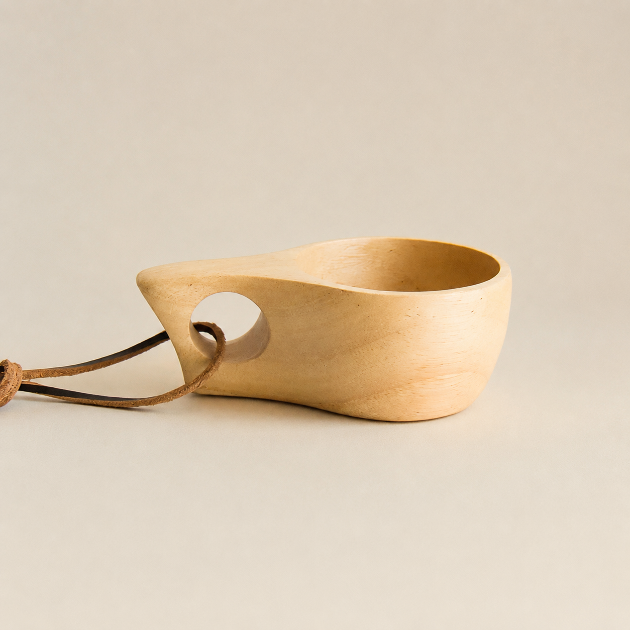 Wooden scoop with a rope handle on a beige background