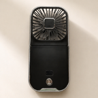 Black handheld fan on a beige background