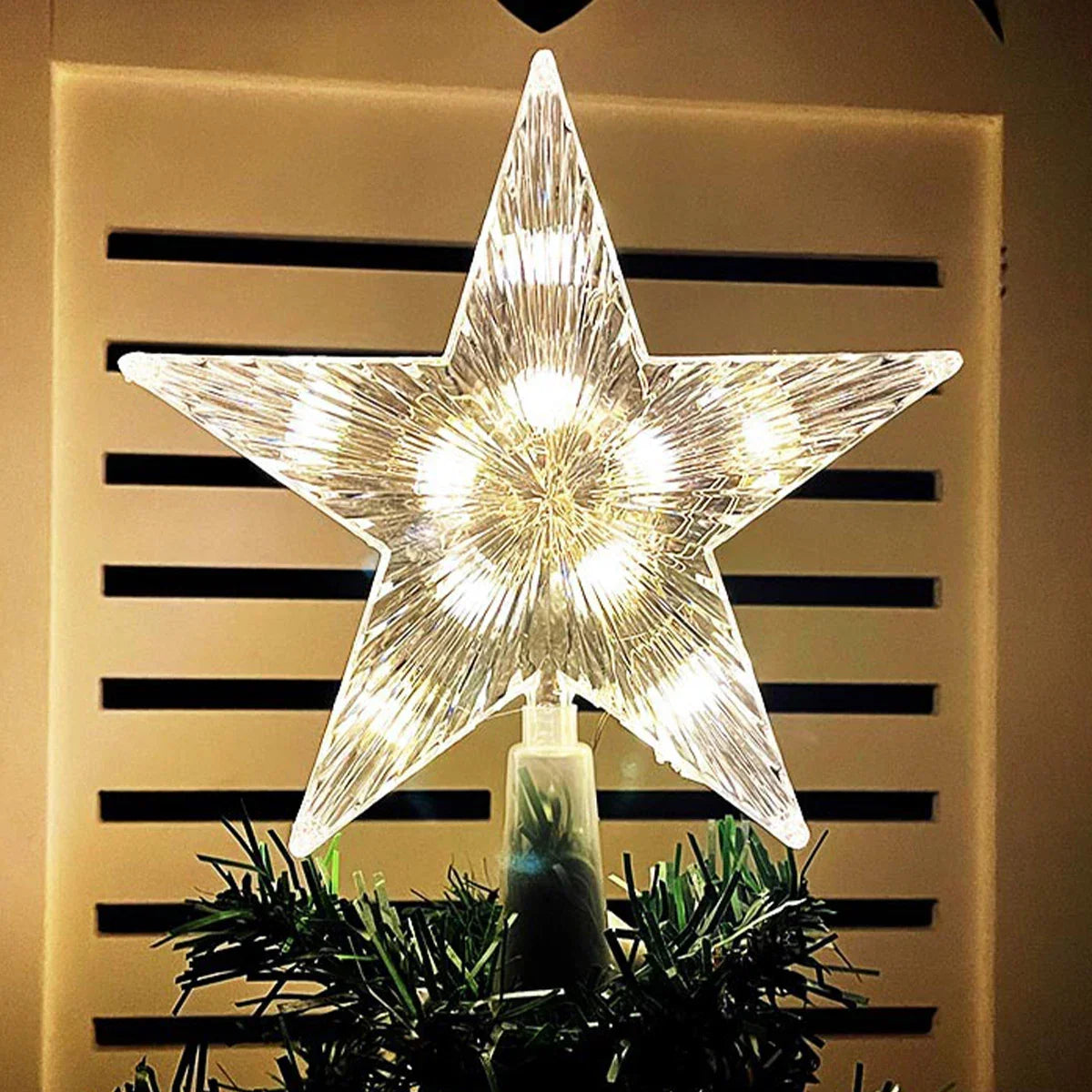 Star-shaped light fixture on a Christmas tree with a neutral background