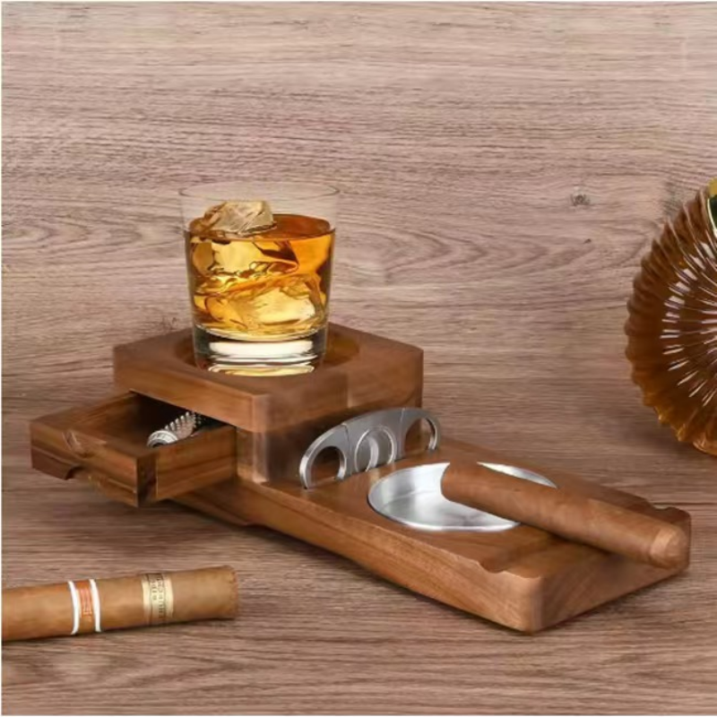 Wooden tray with glass of whiskey, cigar, and accessories on a wooden surface