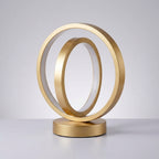 Gold circular sculpture on a gray background