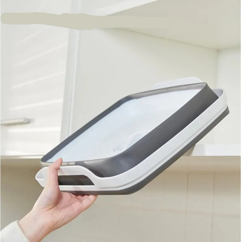 Hand holding a gray and white air filter against a kitchen background