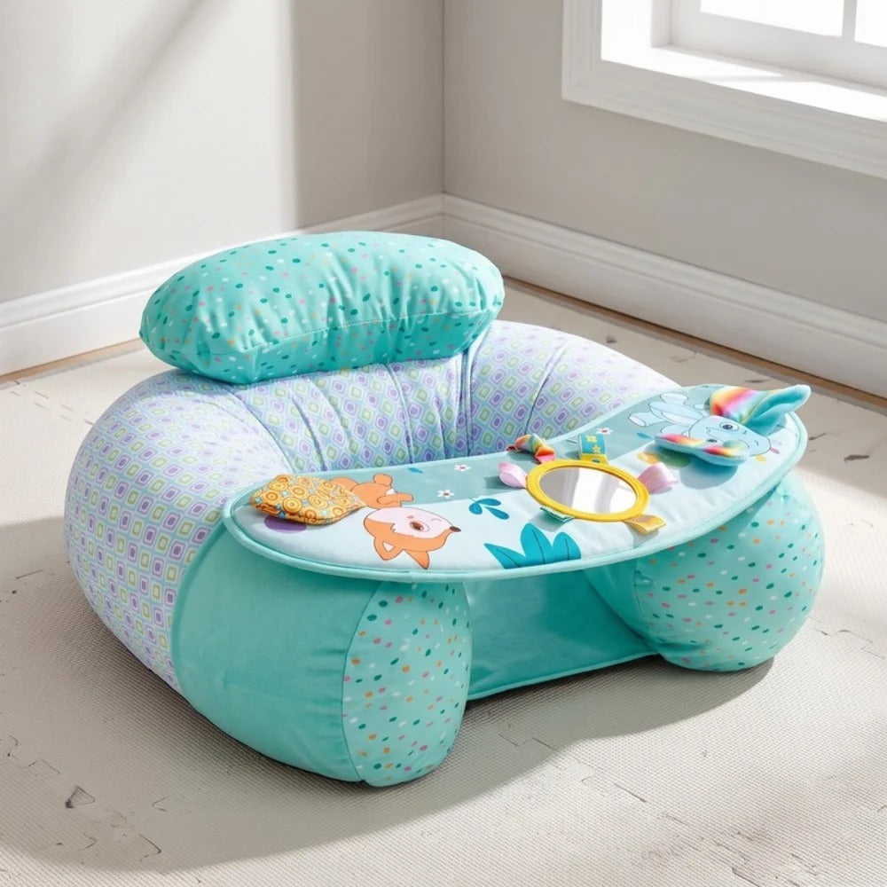 A baby activity seat in mint green and lavender with a patterned fabric, featuring a built-in headrest, a tray with colorful animal toys, and a small mirror, shown in a brightly lit room corner.